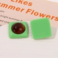 Detail showing green square resin earring studs with amber texture inlay and smooth finish - Green