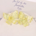 Detailed macro view of yellow iridescent acrylic butterfly charms with fine textures - Yellow