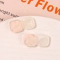 Detail of square resin accessories with soft pink smiley faces and marbled smoke texture - White