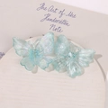 Macro view of translucent light blue iridescent acrylic butterfly charms for DIY jewelry - Blue