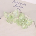 Detailed view of translucent light green acrylic butterfly hair clips with iridescent finish - Green