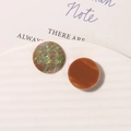 Macro shot of colorful resin round cabochons with iridescent and amber patterns - Brown