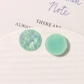 Detailed macro view of mint green resin and iridescent glitter geometric earring charms - Green