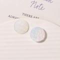 Macro detail of round resin earring charms with iridescent starry sky oil painting texture - White