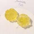 Macro detail of yellow resin rose pendants with translucent finish on a white plate - Yellow