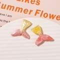 Close-up of glittery gradient resin mermaid tails for DIY jewelry and crafts - Yellow