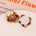 Macro shot of gold floral sequins with center crystal and felt back for DIY clothing - Earth Orange