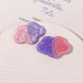 Vista macro de dijes de resina de nube con degradado rosa y morado brillante para DIY - Púrpura
