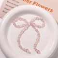 Macro detail of a handmade pink crystal beaded bow accessory for DIY hair clips and jewelry - Pink