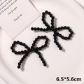 Detailansicht handgefertigter schwarzer Perlen-Schleifen auf einem weißen Keramiktablett - Stil 9 (6.5*5.6cm) / Schwarz