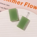 Detalle de colgantes rectangulares de resina verde musgo con bucles para pendientes DIY - Verde