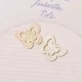 Detail of glittery acrylic butterfly charms with hanging holes for DIY shoe accessories - Pink
