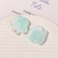 Close-up of translucent aurora resin rose charms with a shimmering finish for DIY crafts - Cyan