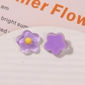 Macro shot of purple resin flower charms with glitter detail and matte finish for DIY crafts - Purple