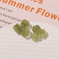 Detail von grünen Acryl-Blütenanhängern für DIY-Schmuck auf weißem, strukturiertem Tablett - 1 Stück / Matcha-Grün
