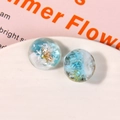 Makro-Detail von Meeres-Resin-Anhängern mit Muscheln und goldenen Seesternen im Inneren - Blau