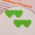 Dettaglio di ciondoli a doppio cuore in acrilico verde frutta su un piatto bianco - Verde Erba