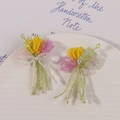 Handmade beaded tulip flower earrings with colorful beads and pearl accents on a plate - Tulip Bouquet Style