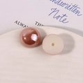 Dettaglio di perle tonde in acrilico che mostrano il lato lucido e il retro piatto forato - Arancione