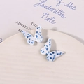 Detailansicht der Schmetterling-Ohrringe aus Acetat mit blauen Punkten auf Creme - Schmetterlings-Design / Blau