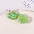 Detail of green heart resin charms with marble texture on white ceramic tray - Light Green