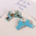 Detailed view of handmade light blue resin bow charms with embedded dried flowers - Blue