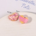 Close-up of pink and gold marble resin heart charms with glitter on a white plate - Pink