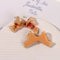 Detail of resin bow accessories with dried flowers on a white textured display plate - Orange