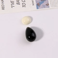 Close-up of polished oval and teardrop resin beads in white and black for DIY jewelry - White Half-Round and Black Waterdrop Set