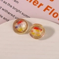 Macro shot of circular resin shoe charms with vintage woven texture and gold metal frame - Red Yellow Gradient