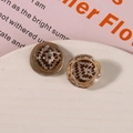 Macro shot of retro resin shoe charms with woven texture and gold metal frame on tray - White Coffee