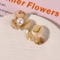 Detailaufnahme von Vintage-Acetat-Blumenohrringen mit Bernstein-Textur und Perlen - Braun