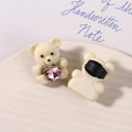 Detail eines cremefarbenen Bären-Anhängers mit rosa Kristallherz und Clip-Rückseite - Gebrochenes Weiß