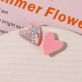 Nahaufnahme von herzförmigen Harzanhängern mit schillernden Muschelflocken für DIY - Rosa