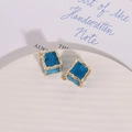 Detailed macro view of irregular square blue charms with textured gold edges for DIY jewelry - Blue
