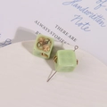 Macro-detail van vierkante harsbedels met gouden tandwielen voor DIY-sieraden maken - Groen