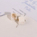 Close-up of steampunk style resin cubes with embedded gold gears for DIY jewelry making - White