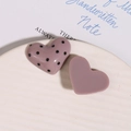 Vista macro dettagliata di ciondoli in resina a forma di cuore a pois su piatto bianco - Rosa
