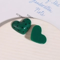 Dettaglio di ciondoli in resina a forma di cuore con pois neri per gioielli fai da te - Verde