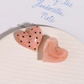 Dettaglio di accessori fai-da-te in resina a forma di cuore con motivi marmorizzati - Rosa