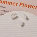 Three translucent white plastic DIY clips for sneakers and jewelry on a white tray - Frosted White