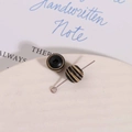 Macro detail of 10mm striped wood beads with a metal T-pin for DIY jewelry making - Black