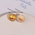 Macro detail of striped resin circular cabochons with high gloss finish on ceramic dish - Yellow Style