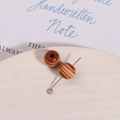 Close-up of 10mm vintage wood beads with natural grain on a ceramic tray for DIY jewelry - Brown