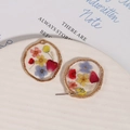 Macro shot of gold alloy resin charms with real dried flowers on white ceramic plate - Alloy Multicolor Dried Flower Style