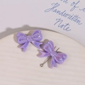 Macro shot of purple resin bow pendants with iridescent pearl finish for DIY jewelry - Purple