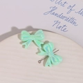 Detail of light green AB iridescent resin bow charms for DIY earring and jewelry making - Green