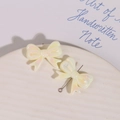 Macro shot of iridescent bow-shaped jewelry pendants with pearlescent finish for DIY - White