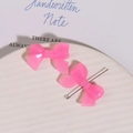 Macro-opname van roze hars strikjes met naald op wit keramisch dienblad voor DIY sieraden - Rozerood