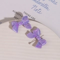 Macro shot of purple iridescent resin bow charms for DIY jewelry and hair accessories - 1 Piece/Pack / Purple
